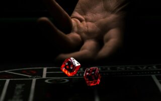 a hand with a finger pointing at a red and white dice